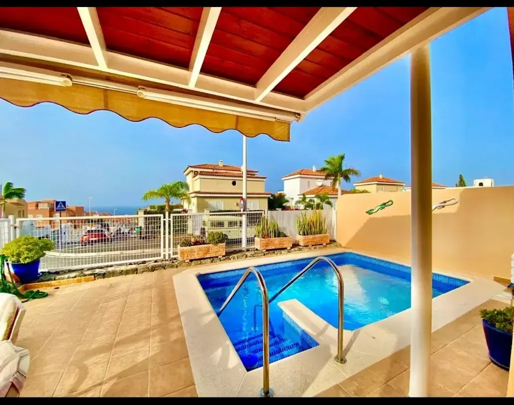 Piscina privada bajo la pérgola con vistas al mar
